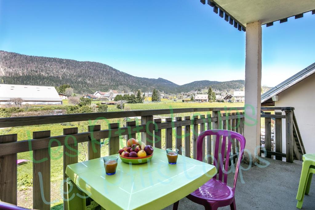 une table avec un bol de fruits sur un balcon dans l'établissement Appartement Les Ptits Loups, à Autrans