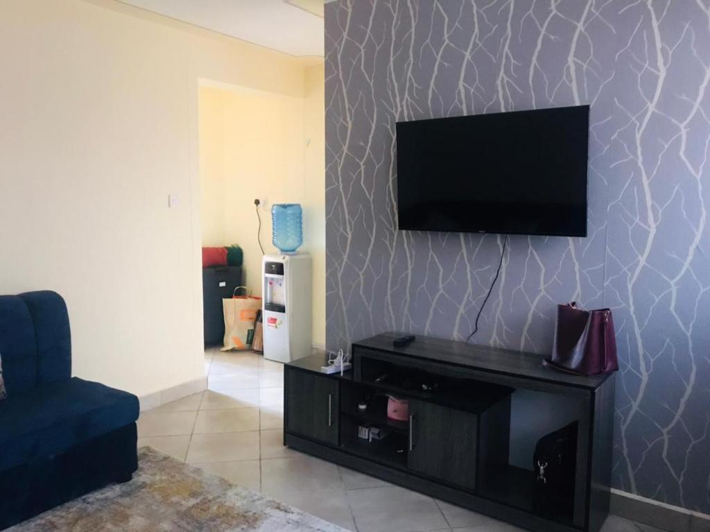 a living room with a flat screen tv on a wall at Citux Homes in Nairobi