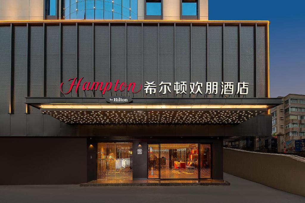 a building with a sign on the side of it at Hampton by Hilton Guangzhou Railway Station in Guangzhou