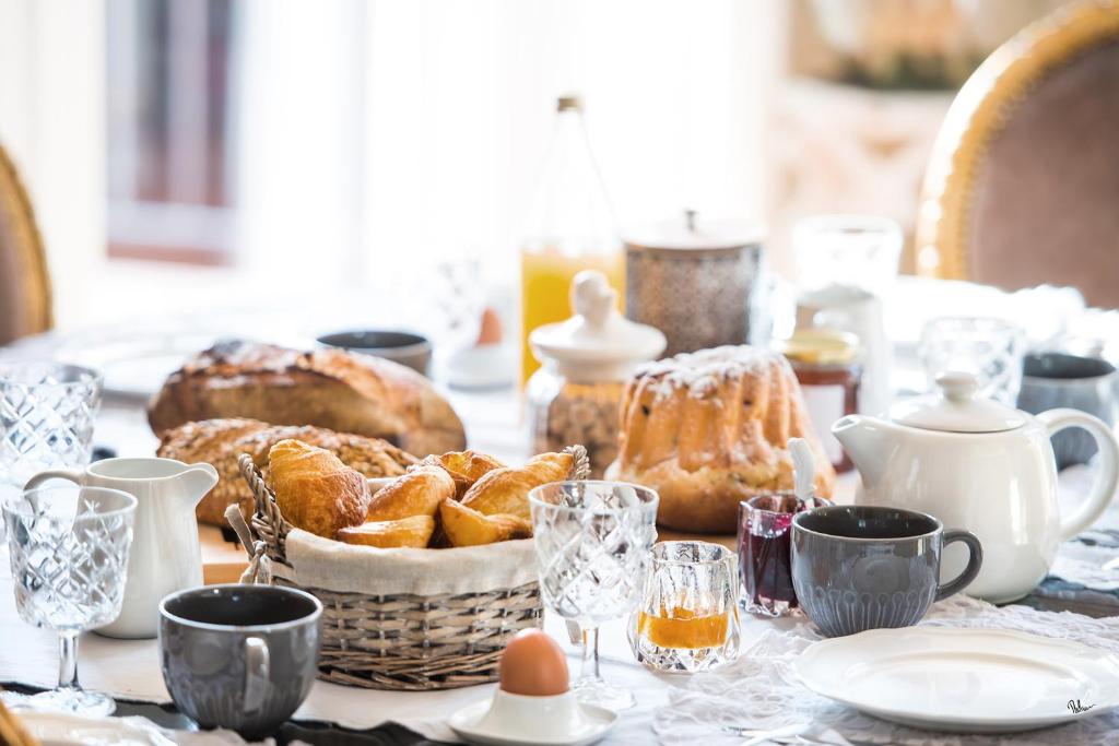 una mesa cubierta con una cesta de pan y huevos en Le Clos Marguerite - Maison d'Hôtes en Ammerschwihr