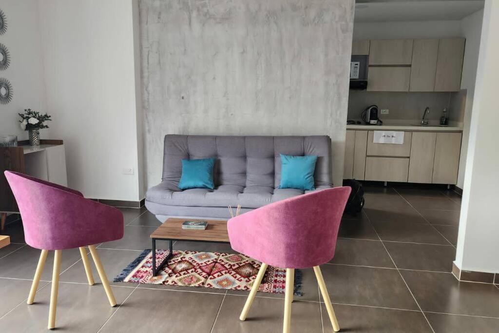 sala de estar con 2 sillas y sofá en Apartamento Moderno, en Pereira