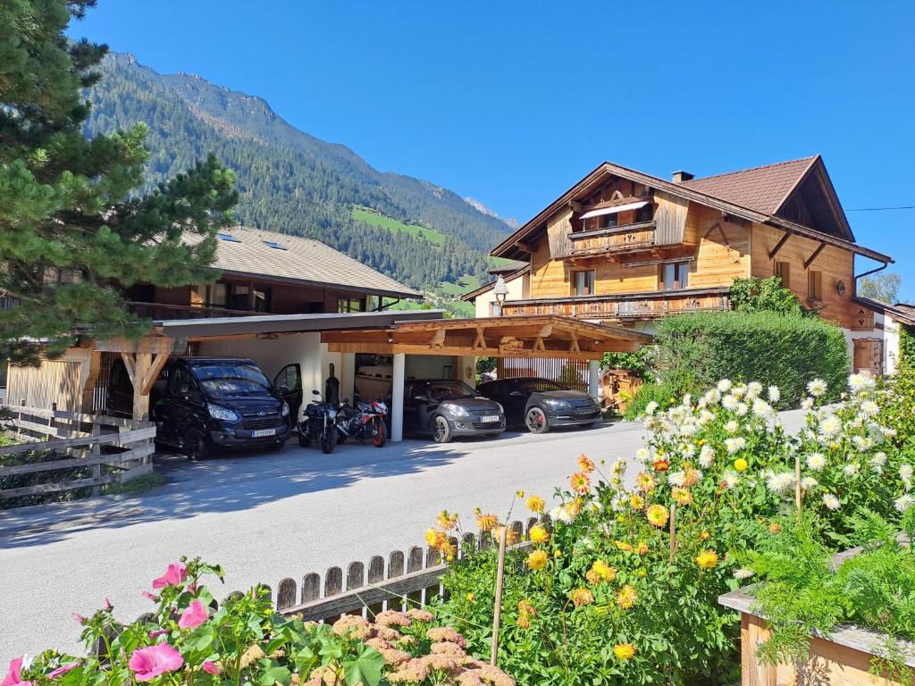 una casa con coches aparcados delante de ella en Ferienwohnung Felix, en Neustift im Stubaital