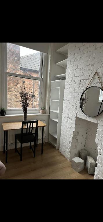 a room with a table and a chair and a window at St Andrews Mansions in London