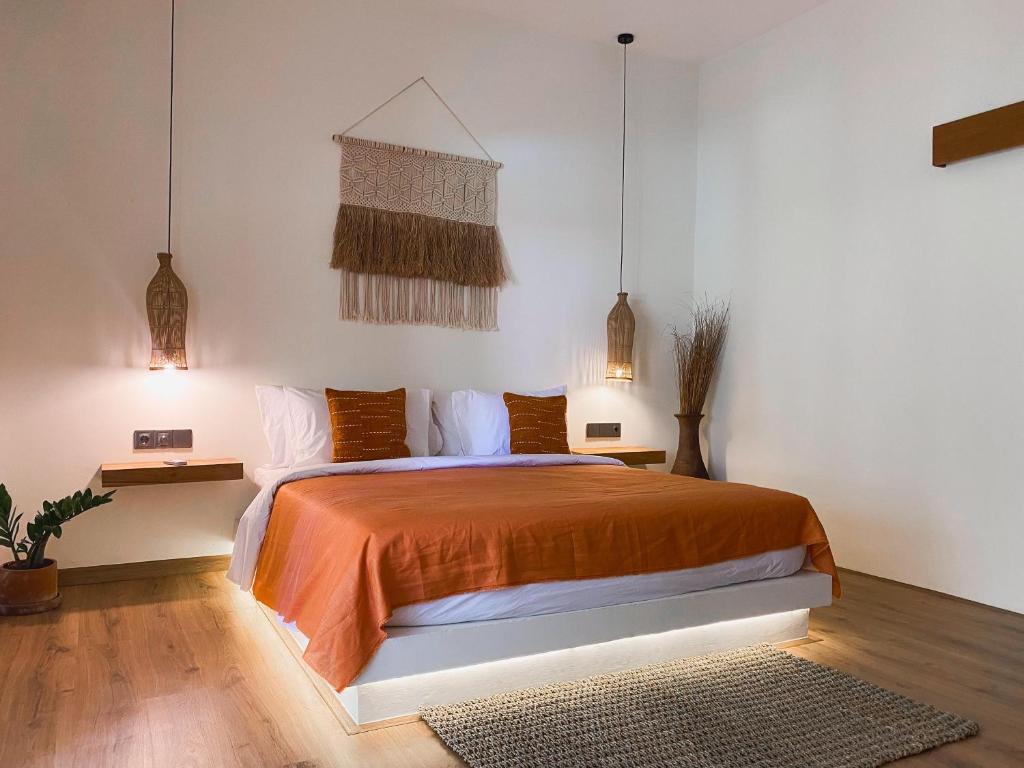 a bedroom with a bed with an orange bedspread at Reset Lombok Hotel in Kuta Lombok