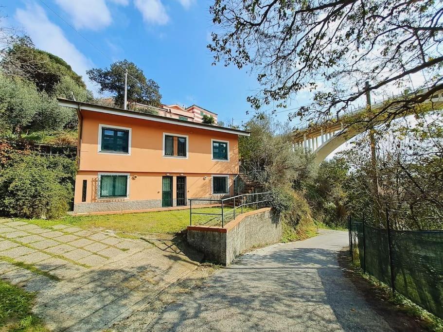 una casa naranja con una valla y un camino en Casa Marina - Tenuta Calano, en Celle Ligure
