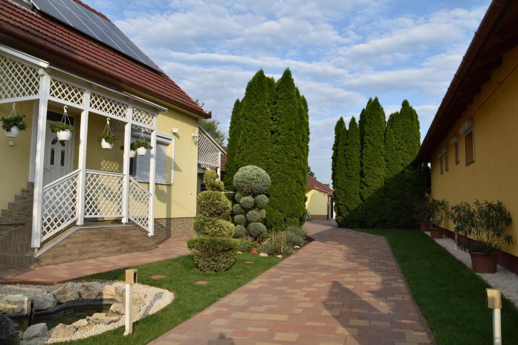 ハイドゥソボスローにあるHarsányi Vendégházの木々と遊歩道のある家の中庭