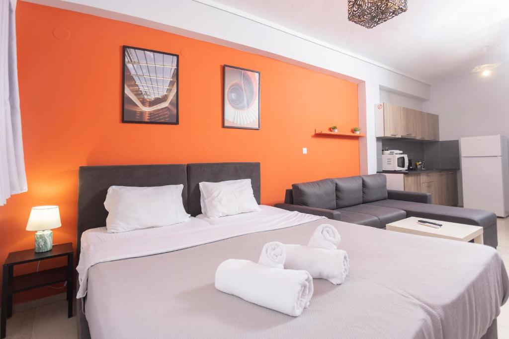 a bedroom with two beds and an orange wall at Downtown Seaside Studios in Thessaloniki