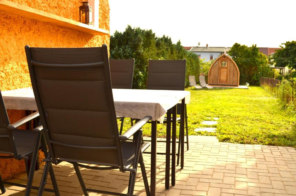 a table and chairs on a patio with a yard at Lehmhäuschen mit Sauna in Tangermünde