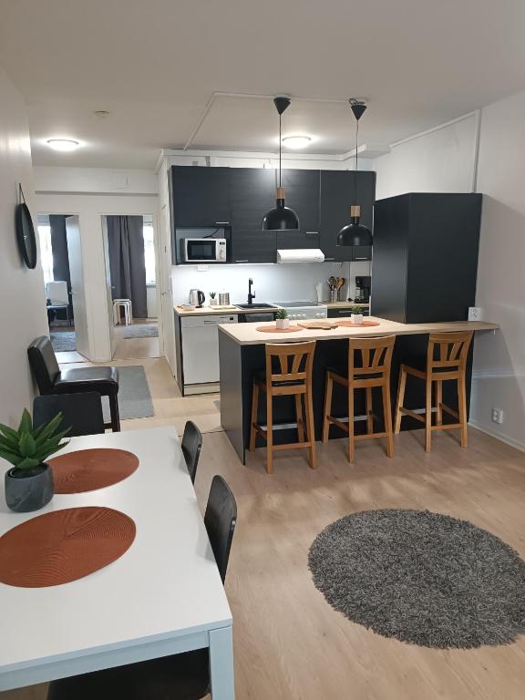 a kitchen and living room with a table and chairs at 2BR Apartment, free parking - Peikontie in Oulu