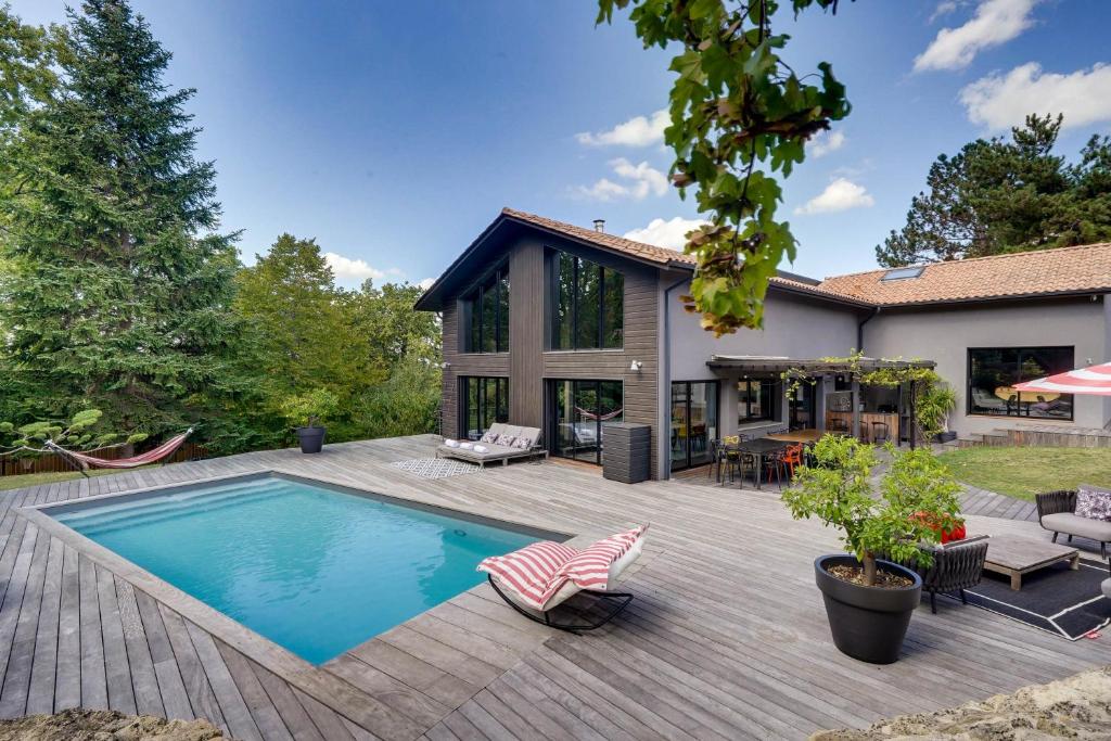 einen Hinterhof mit einem Pool und einem Haus in der Unterkunft Villa La Forêt • Piscine Parking & Wi-Fi in Sainte-Eulalie