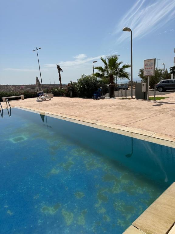 uma piscina com água azul num parque de estacionamento em Residence tafoult imi ouadar taghazout em Agadir nʼ Aït Sa