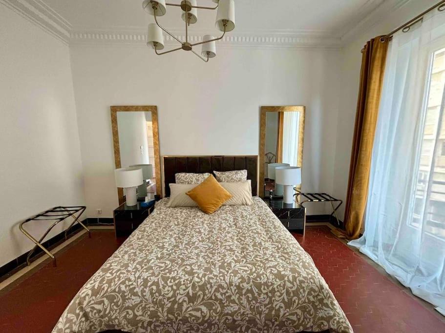 - une chambre avec un grand lit et deux miroirs dans l'établissement Blue horizon Prenium, à Marseille