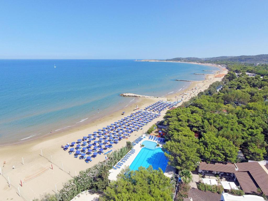 - une vue aérienne sur une plage avec une piscine et des parasols dans l'établissement Villaggio Gabbiano Beach, à Vieste