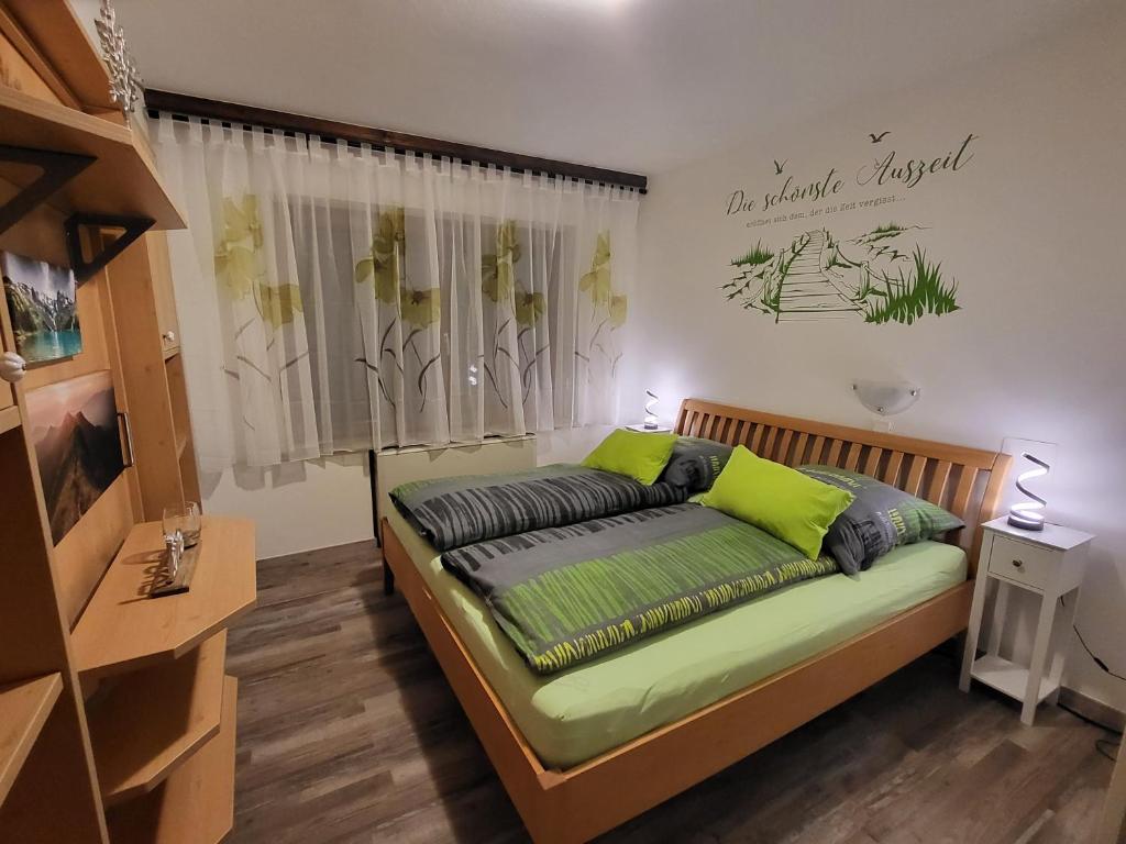 a bedroom with a bed with green pillows on it at Auszeit am Berg in Schwarzach im Pongau