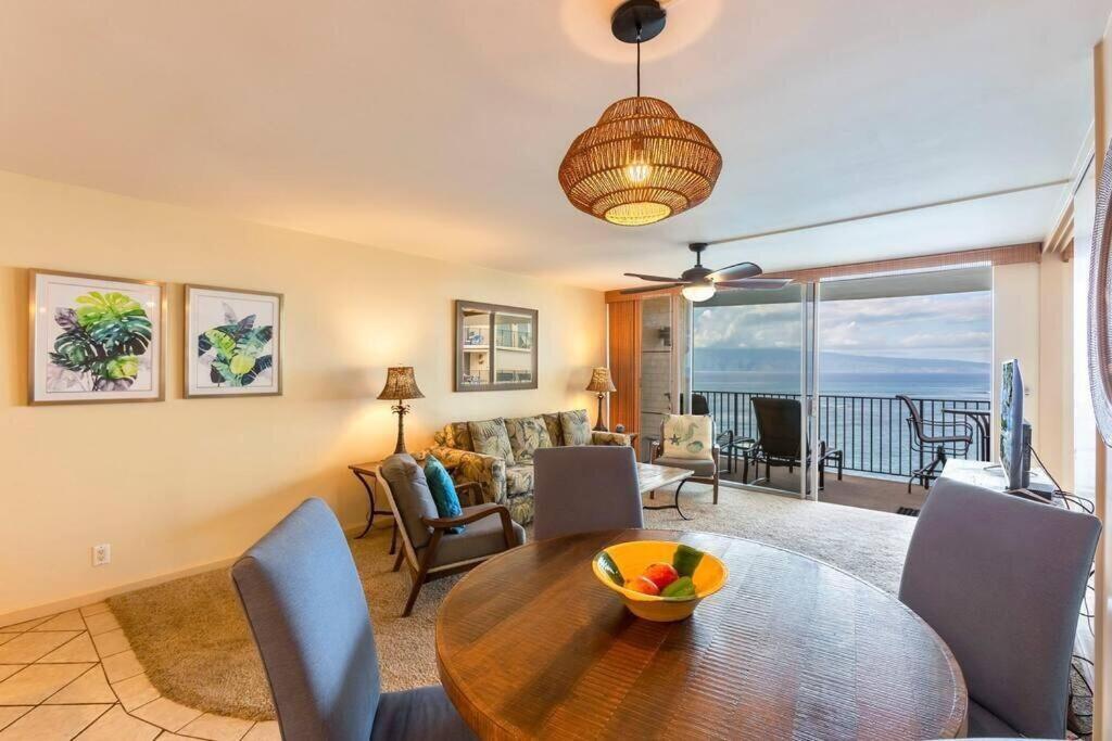 a living room with a table and chairs and a view of the ocean at Hololani B603- Beautiful ocean views at this 2 bedroom condo in Kahana