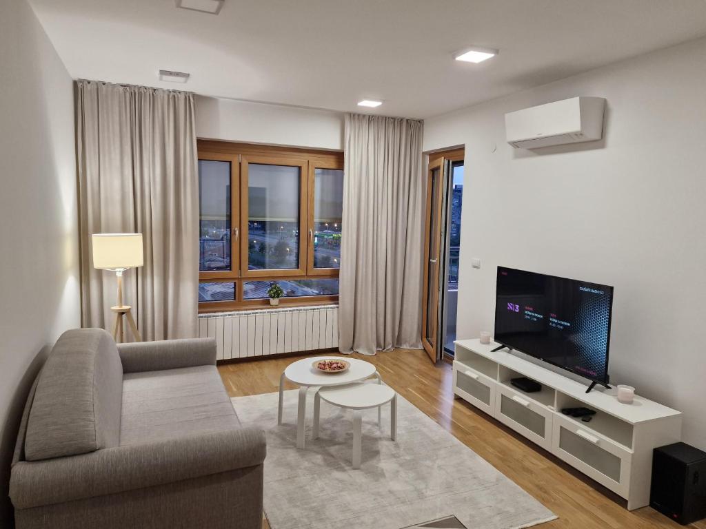 ein Wohnzimmer mit Couch und Fernseher in der Unterkunft Oaza 45 in Belgrad
