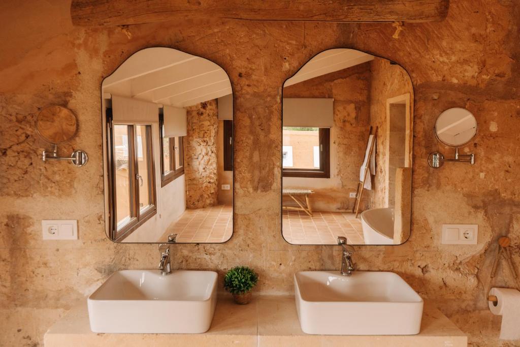 La salle de bains est pourvue de 2 lavabos et de 2 miroirs. dans l'établissement Claudia by Nura, à Campos