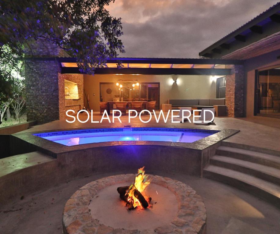 a fire pit in a backyard with a sign that reads solar powered at Kruger Nights in Marloth Park