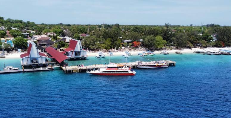 a group of boats docked at a dock on a beach at Gili Ferries ticket in Padangbai