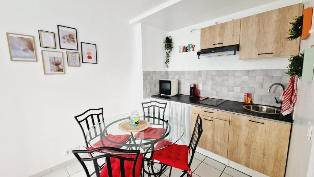 een kleine keuken met een tafel en stoelen. bij Happy Home in Pontault-Combault