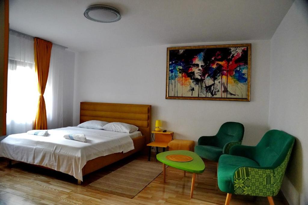 a bedroom with a bed and two green chairs at Anto1 in Călăraşi