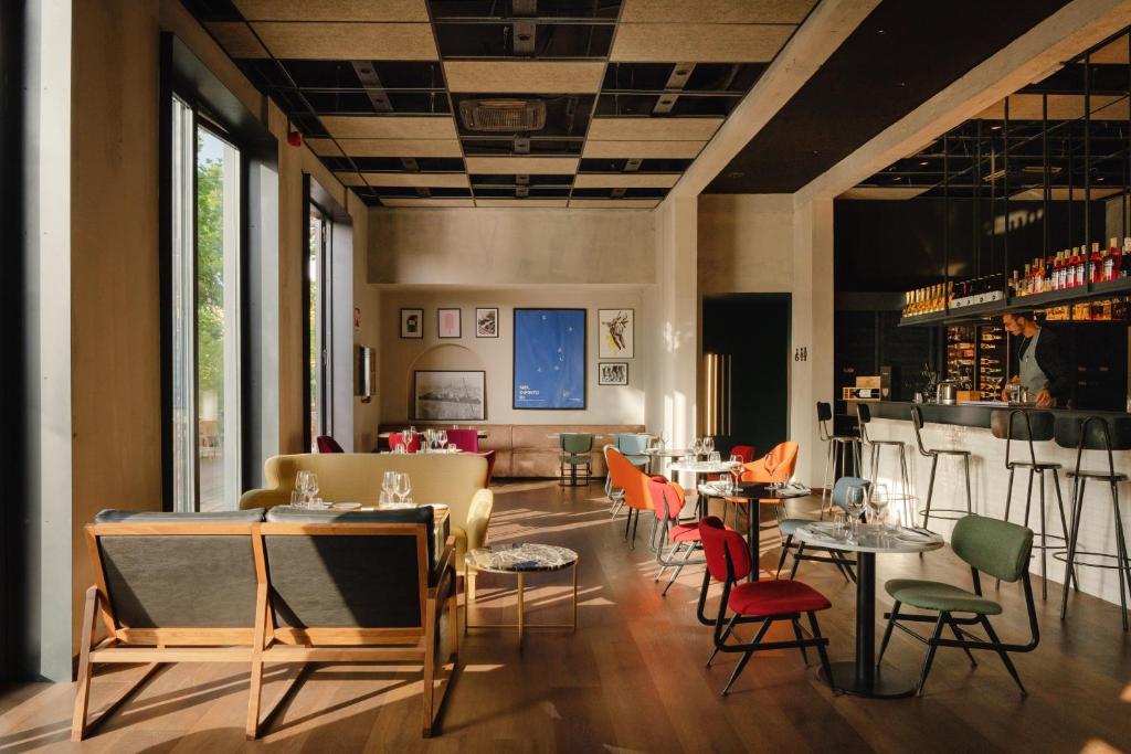 a restaurant with tables and chairs and a bar at Re Versiliana Hotel in Marina di Pietrasanta