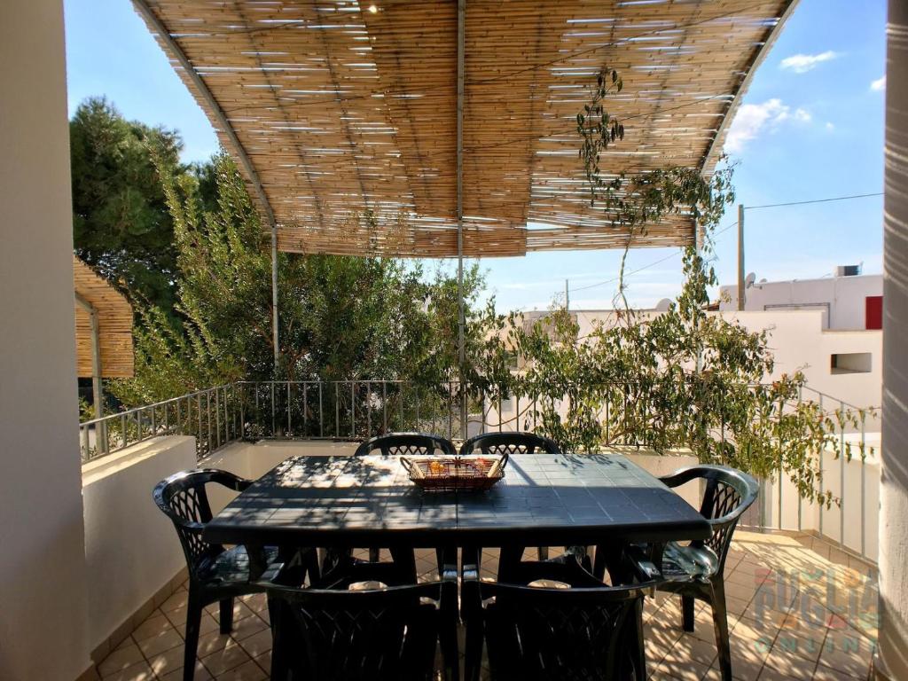 un patio con mesa y sillas bajo un techo de madera en Villetta Daversa 2 a Torre Vado, en Torre Vado