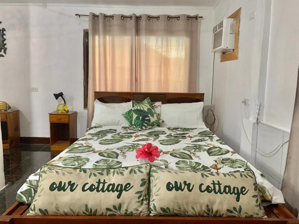 a bedroom with a bed with a flower on it at Panagsama Holiday Cottage in Moalboal