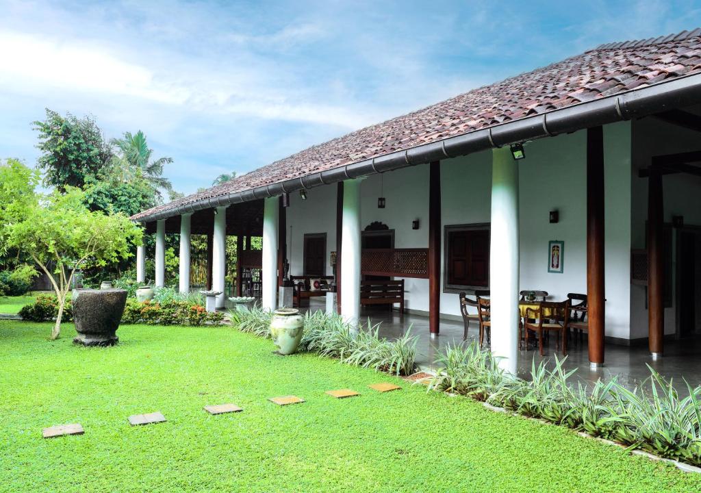 um edifício com um quintal relvado e um pátio em Samudra Villa em Ambalangoda