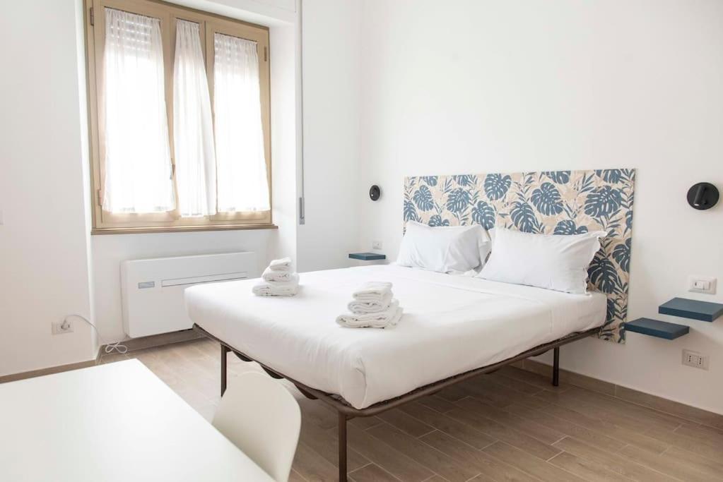 um pequeno quarto com uma cama com toalhas em Domus Viola in San Giovanni em Roma