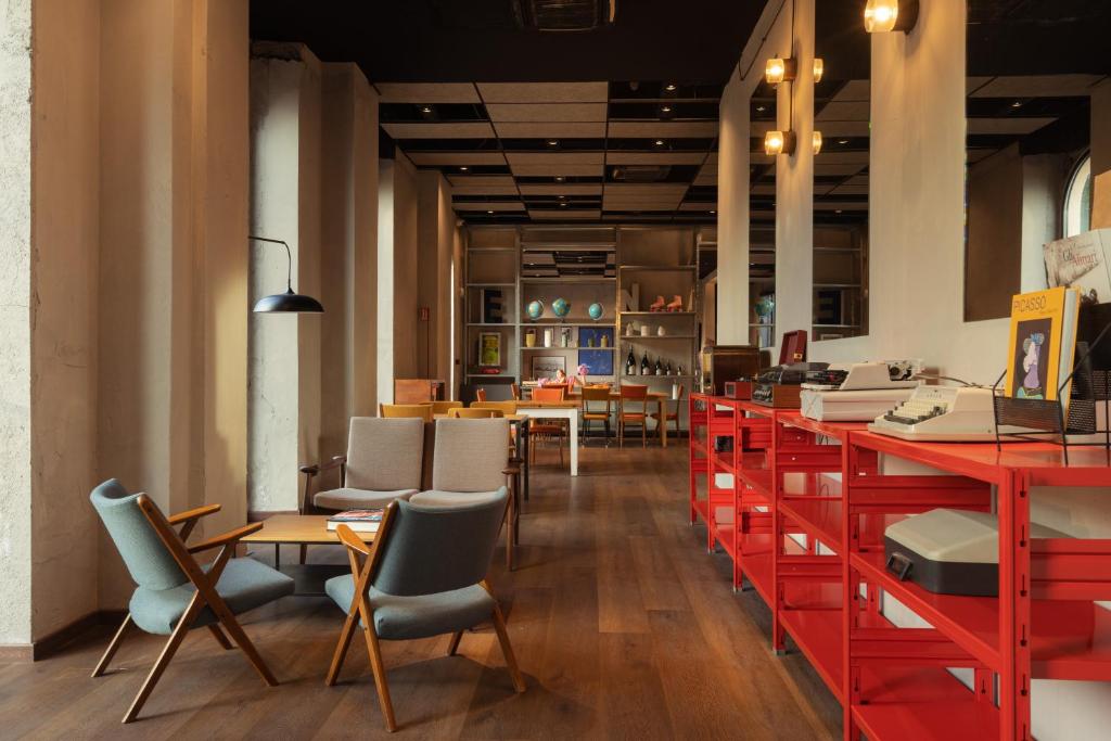 a restaurant with red tables and chairs at Re Versiliana Hotel in Marina di Pietrasanta