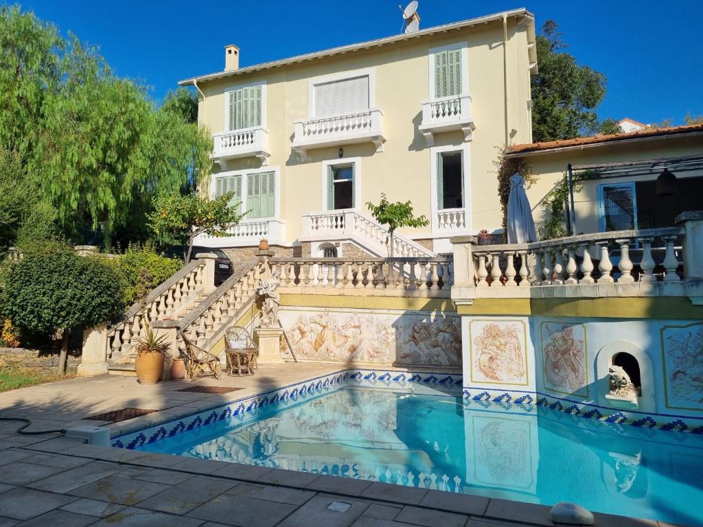 a villa with a swimming pool in front of a house at Villa Marguerite in Hyères