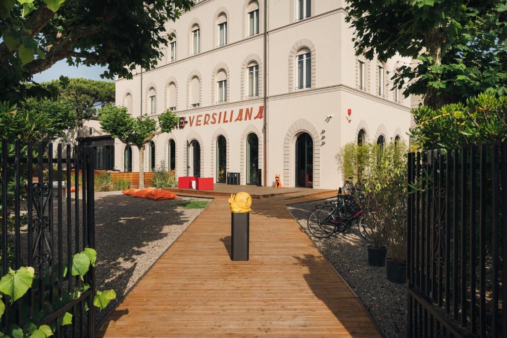 a building with a wooden walkway in front of it at Re Versiliana Hotel in Marina di Pietrasanta