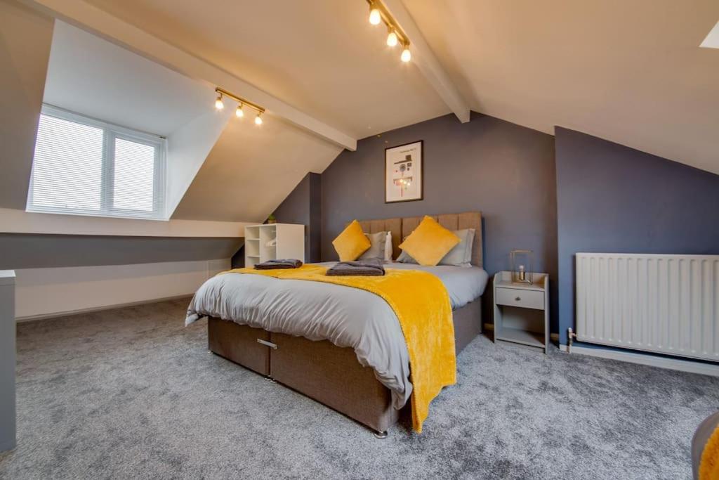 een slaapkamer met een groot bed en een gele deken bij Guest Road - Stylish 3 Bedroom House in Nether Edge