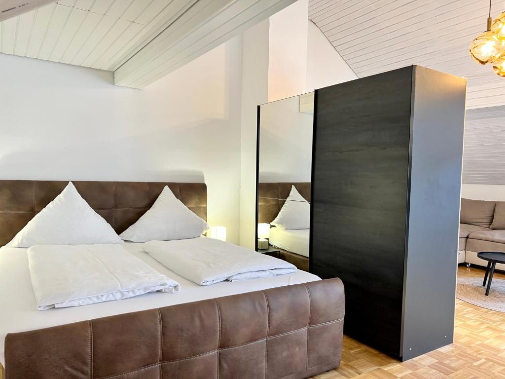a bedroom with a large bed with a leather headboard at Ferienhaus Möhrle 7 in Überlingen