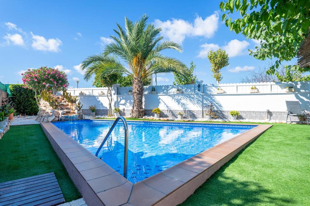 una piscina en un patio con una palmera en Traditional Villa, en Creixell