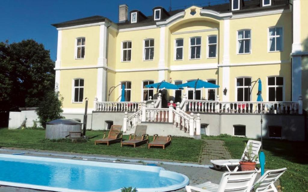 a large house with a swimming pool in front of it at Schloss Schmuggerow in Schmuggerow