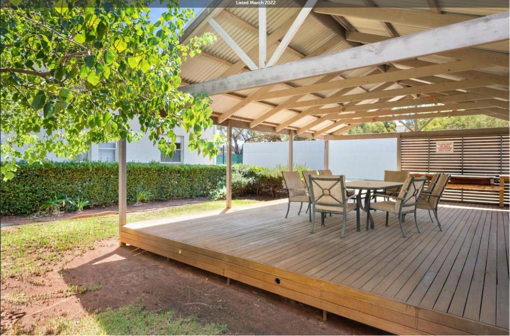 a wooden deck with a table and chairs on it at Kalgoorlie Accommodation in Kalgoorlie