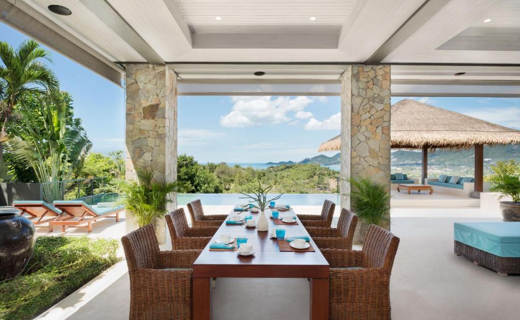 a dining room with a table and chairs and a view of the ocean at Baan Kimsacheva - Seaview Private Villa in Choeng Mon Beach