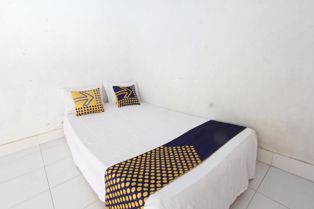 a bed with two pillows on it in a room at OYO Life 93153 Kos Jenggala in Tanjung