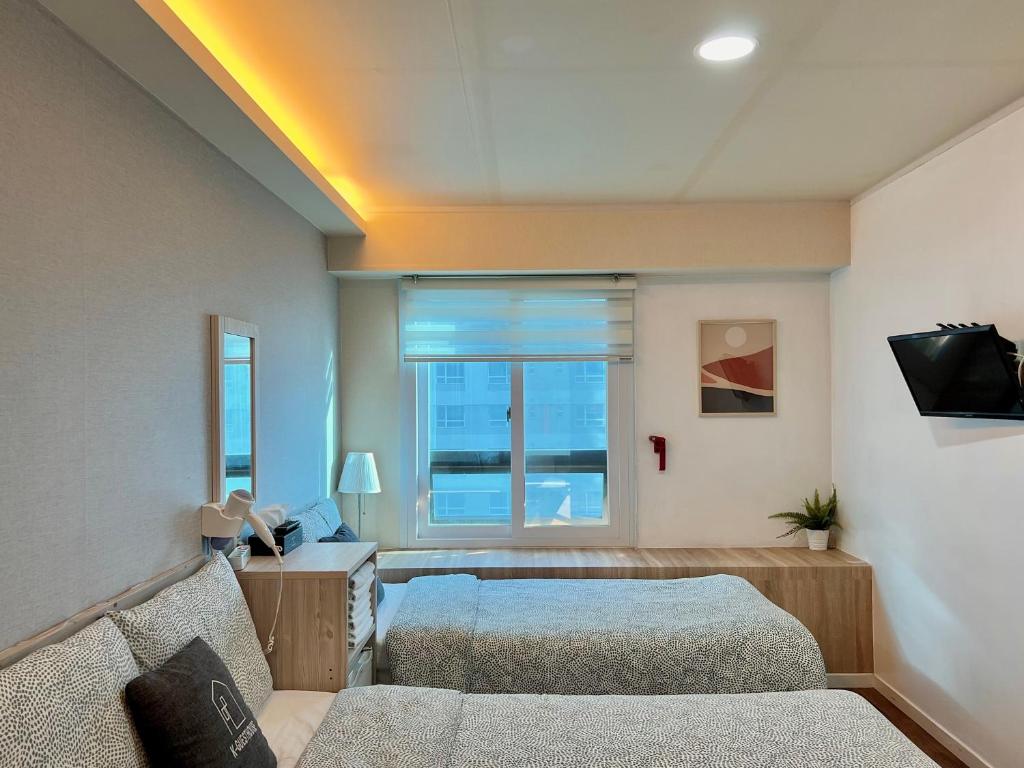 um quarto com 2 camas e uma janela em Seoul Grand Hostel EWHA Univ em Seul