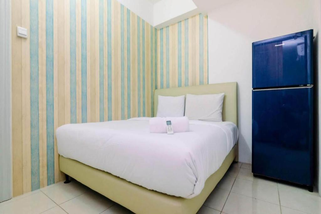 a bedroom with a large white bed and a blue cabinet at OYO LIFE ROOMS BY MIXO in Jakarta