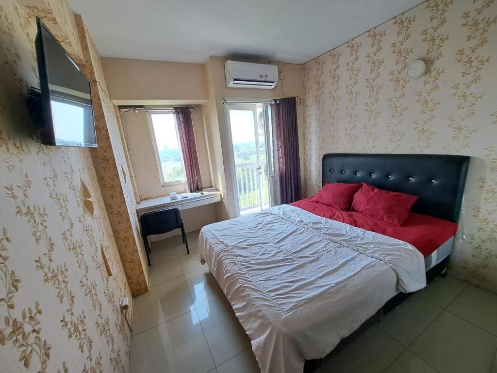 ein Schlafzimmer mit einem Bett mit roten Kissen darauf in der Unterkunft OYO Life 93106 Apartement Grand Sentraland By Andi in Karawang