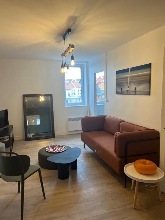 een woonkamer met een bank en een tv bij Appartement comme à la maison refait à neuf in Boulogne-sur-Mer
