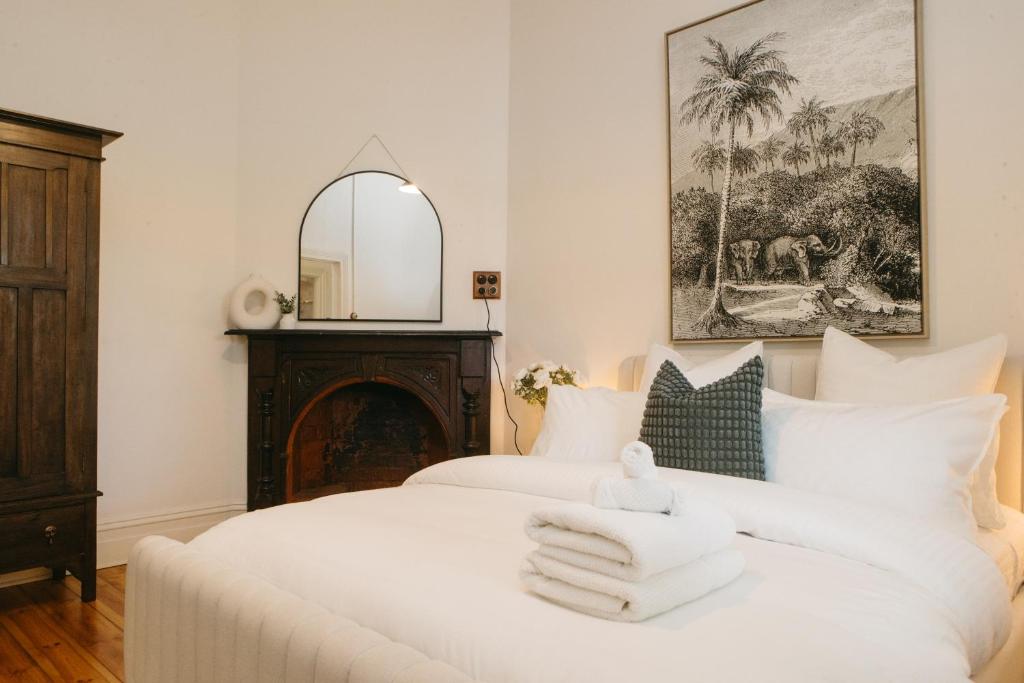een slaapkamer met een wit bed en handdoeken bij Luxurious terrace home in heart of town in Bendigo