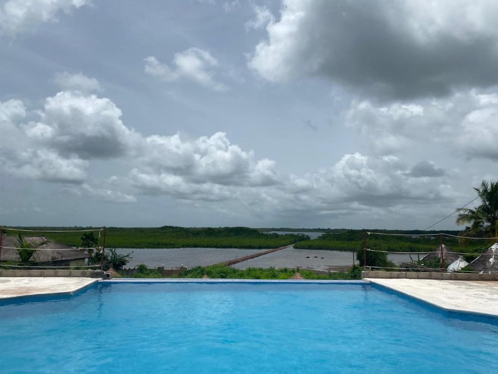 a swimming pool with a view of a body of water at Toubacouta Lodges in Toubakouta