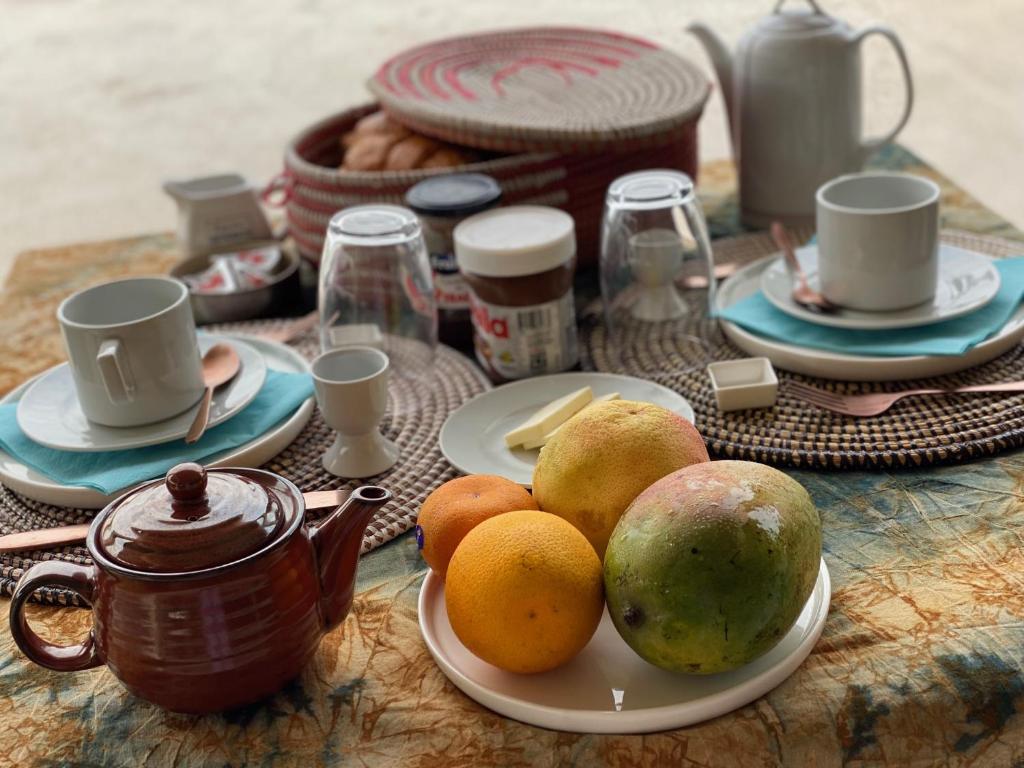 a table with a plate of fruit and a tea pot at Toubacouta Lodges in Toubakouta
