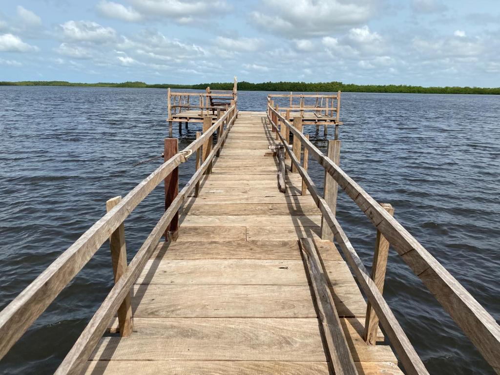 a wooden dock in the middle of a body of water at Toubacouta Lodges in Toubakouta
