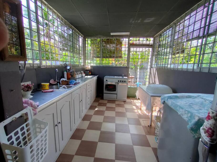 a kitchen with white cabinets and a checkered floor at The Bungalow Homestay by Cheta in Alor Setar