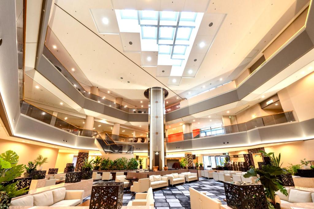 a large lobby with white furniture and a large skylight at HOTEL FUKURACIA OSAKA-BAY in Osaka